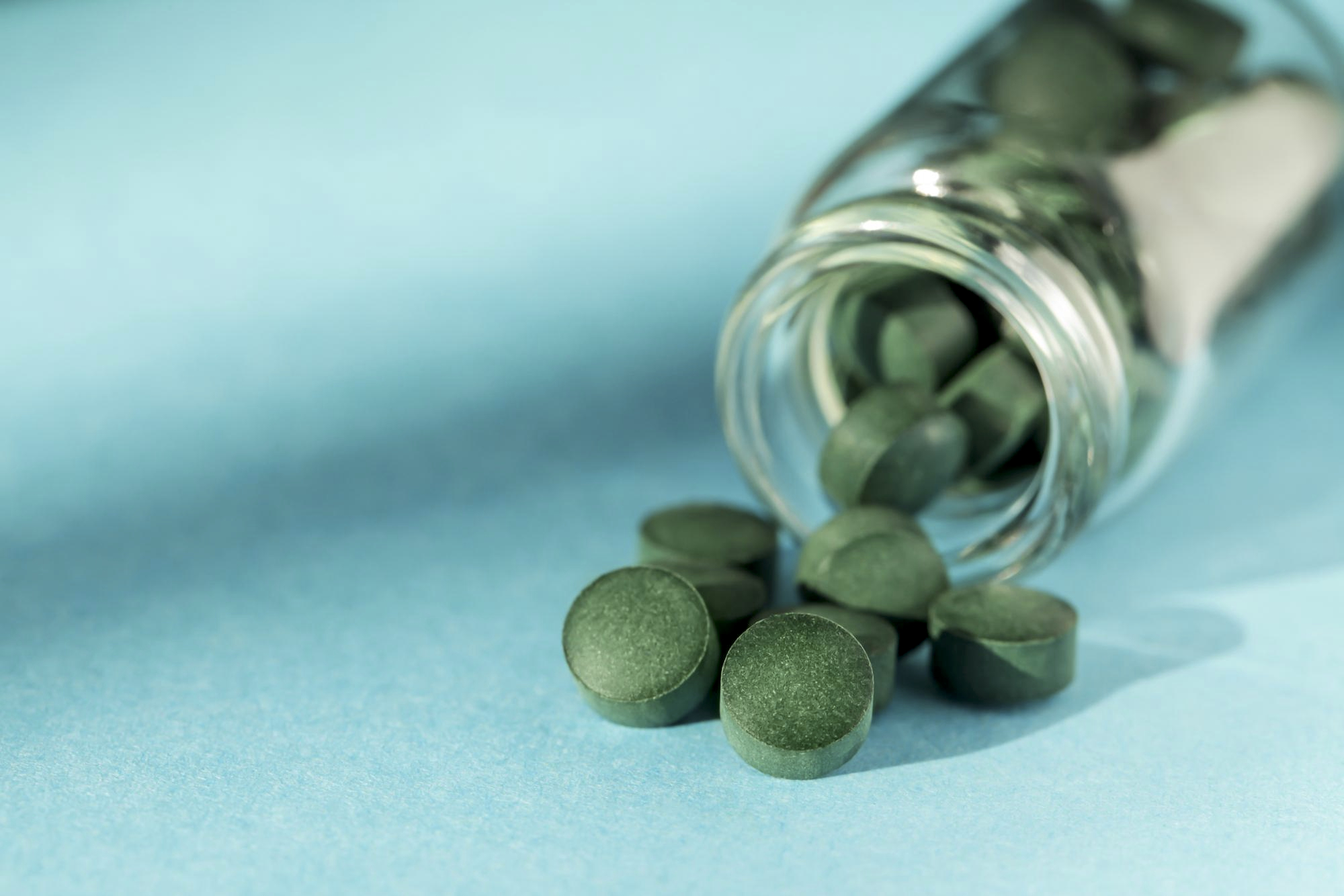 Green tablets poured from a jar